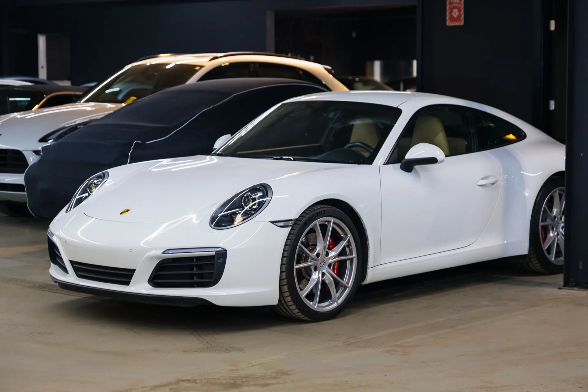 White Porsche 911 parked inside M Sport Motorwerx